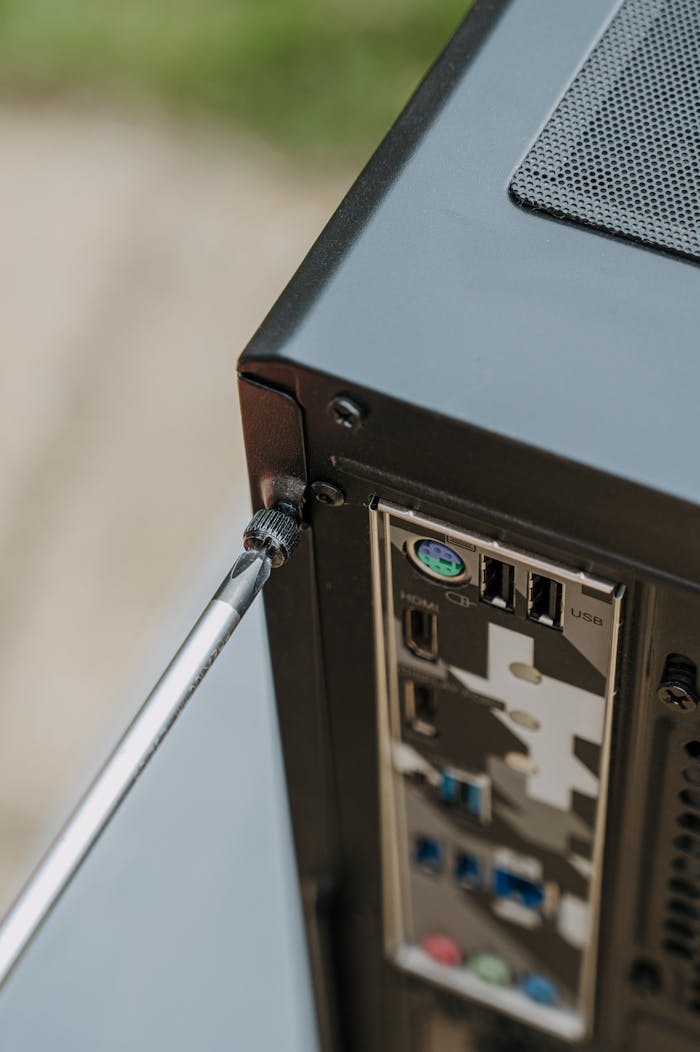 Close-up of unscrewing a PC's back panel for DIY maintenance.