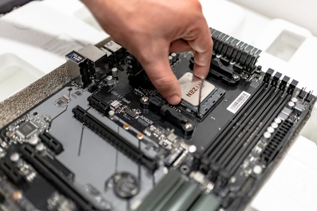 Person's hand installing a CPU on a motherboard, showcasing PC maintenance and repair.